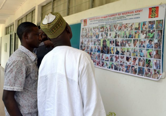 Varias personas miran un cartel con presuntos yihadistas de Boko Haram (AFP)